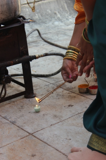 Lighting a candle in the blessing of the stove